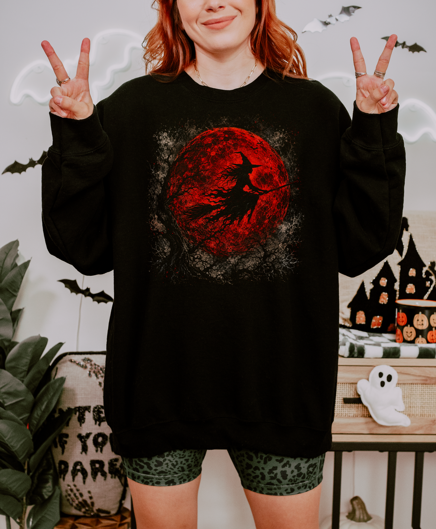 Black Gildan crewneck sweatshirt with a red moon and flying witch graphic